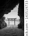A monochrome landscape of a seaside torii gate and its mystical approach, viewed through the rocks. 143519733