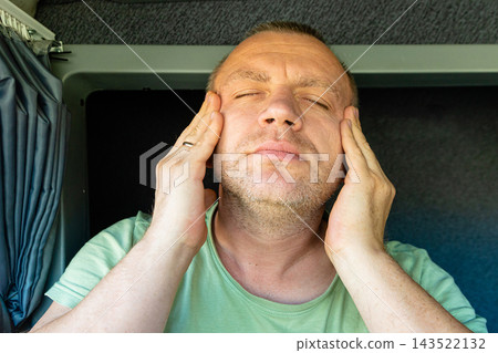 Tired man rubbing his temples with closed eyes suffering from migraine Tired man rubbing his temples with closed eyes suffering from migraine 143522132