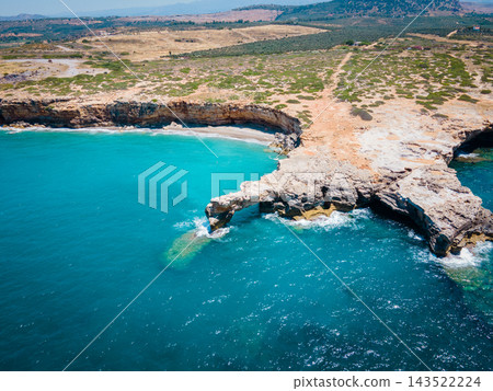 Sunny Beach with Waves in Rethymno, Crete. A beautiful wild beach in Rethymno, Crete, Greece, just before the main port. Gentle waves roll onto the untouched shoreline under the warm sun, creating a p Sunny Beach with Waves in Rethymno, Crete. A beautiful wild beach in Rethymno, Crete, Greece, just before the main port. Gentle waves roll onto the untouched shoreline under the warm sun, creating a p 143522224