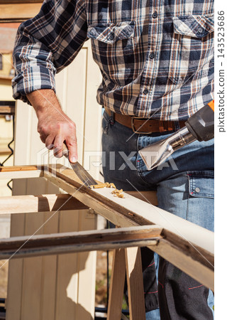 Carpenter at work, restoring an old wooden window. Carpentry. Carpenter at work, restoring an old wooden window. Carpentry. 143523686