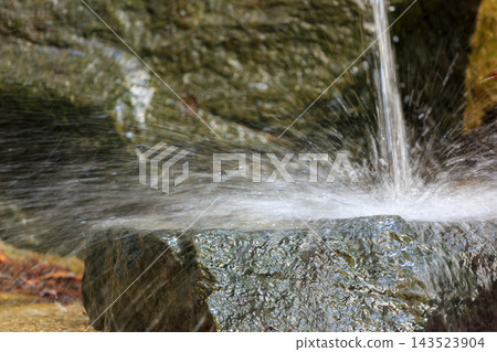 Water splashes as it hits the rocks Water splashes as it hits the rocks 143523904