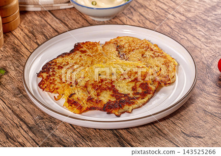 Crispy golden potato pancakes on white plate with creamy dip Crispy golden potato pancakes on white plate with creamy dip 143525266