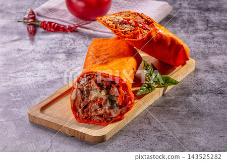 Wooden board, red tortilla chicken shawarma wraps with vegetables and basil leaf, Middle Eastern street food 143525282