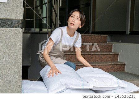 Woman setting up sandbags Woman setting up sandbags 143526235