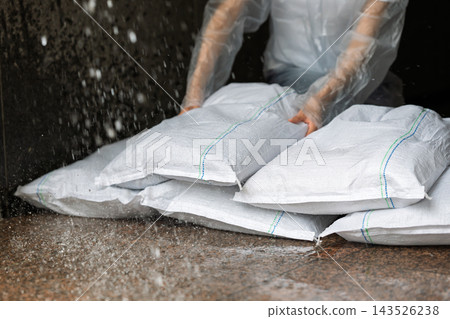 Woman setting up sandbags Woman setting up sandbags 143526238