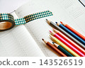 A notebook, colorful colored pencils, and masking tape. 143526519