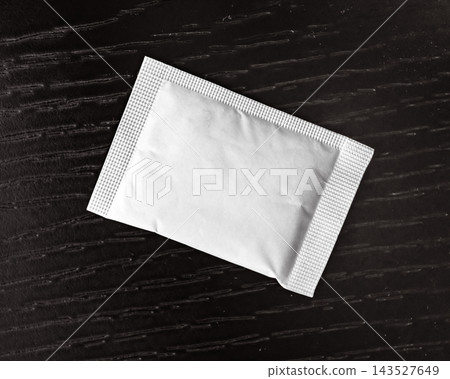 Blank white sachet mockup packet on wooden surface Blank white sachet mockup packet on wooden surface 143527649