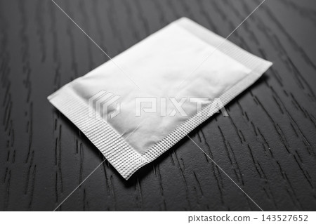 selective focus of blank white sachet mockup packet on wooden surface selective focus of blank white sachet mockup packet on wooden surface 143527652