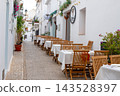 Charming Altea street scene inviting travelers to outdoor dining at a cafe in Spain, perfect for family holidays and relaxing vacations 143528397