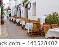 Restaurant terrace on a historic cobblestone street in Altea Spain awaits guests for a delightful al fresco dining experience during a memorable family holiday 143528402