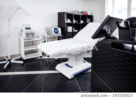 Medical treatment room featuring a white examination table, modern equipment, and organized storage, creating a clean and professional healthcare environment for patient care Medical treatment room featuring a white examination table, modern equipment, and organized storage, creating a clean and professional healthcare environment for patient care 143530023