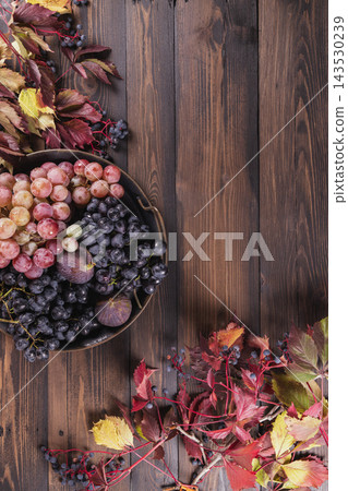 Autumn harvest concept with grapes and figs on wood Autumn harvest concept with grapes and figs on wood 143530239