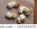 Four peeled porcini mushrooms closeup on parchment 143530470