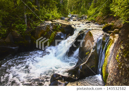 Waterfall Flowing Over Mossy Rocks in Lush Forest Landscape 143532582
