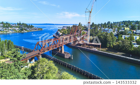 Aerial Train Bridge Over Waterway With Seattle Neighborhoods And Construction Activity Aerial Train Bridge Over Waterway With Seattle Neighborhoods And Construction Activity 143533332