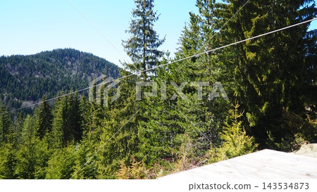 Nova Varos, Zlatar, Serbia. Cable inclined rope is ridden from height gravity influence is zipline or troll. Zipline, zip-line or funiculaire downhill in mountains, parks and canyons. Nova Varos, Zlatar, Serbia. Cable inclined rope is ridden from height gravity influence is zipline or troll. Zipline, zip-line or funiculaire downhill in mountains, parks and canyons. 143534873