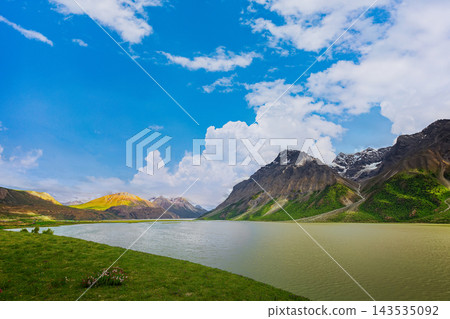 Serene Mountain Lake on the Tibetan Plateau with Snow Capped Peaks and Blue Sky Serene Mountain Lake on the Tibetan Plateau with Snow Capped Peaks and Blue Sky 143535092