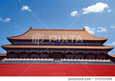 The Forbidden City in Beijing, China, with its iconic red walls and golden roofs under a blue sky. 143535096