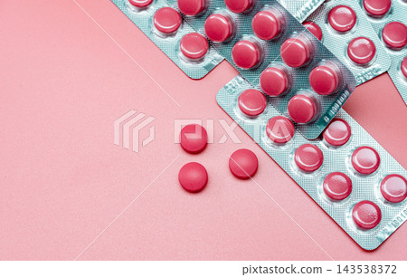 Top view of pink tablets pill and blister pack of pills on pink background. Prescription drugs. Pharmaceutical industry. Pharmacy drugstore banner. Health care and medicine. Tablets pills production. Top view of pink tablets pill and blister pack of pills on pink background. Prescription drugs. Pharmaceutical industry. Pharmacy drugstore banner. Health care and medicine. Tablets pills production. 143538372