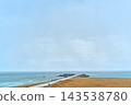 Beach sand management with jetty structure at overcast coastal location 143538780