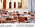 Striped house cat sleeping on cafe terrace table Kotor Montenegro old town square 143538960