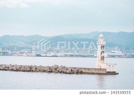 海邊的城鎮景色和防波堤上的白色燈塔 海邊的城鎮景色和防波堤上的白色燈塔 143539555