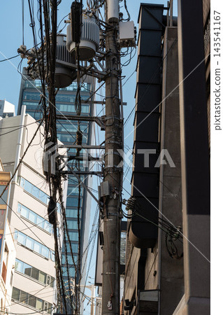 建築物之間密密麻麻地佈滿了電線桿和複雜的線路。 建築物之間密密麻麻地佈滿了電線桿和複雜的線路。 143541167