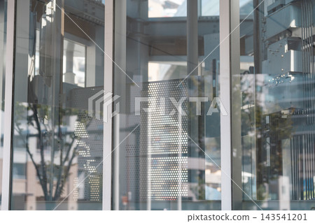 透過玻璃可以看到金屬裝置和建築物的倒影。 143541201