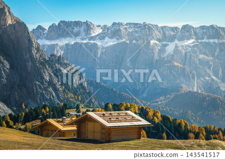 Wooden huts and autumn larch trees in the Dolomites, Italy Wooden huts and autumn larch trees in the Dolomites, Italy 143541517