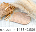 Dried flowers and an arch-shaped wooden plate 143541689