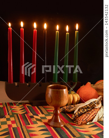 Kwanzaa celebration with lit kinara and unity cup Kwanzaa celebration with lit kinara and unity cup 143542132