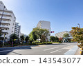Under the blue sky, apartment complexes stand in a lush, green residential area with wide roads. 143543077