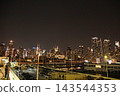 A view of Manhattan's skyscrapers and the harbor at night from a ship. 143544353