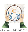 Watercolor illustration of hands stitching a crescent moon and blue flowers in a wooden embroidery hoop, showing handmade needlework in progress for textile crafts, tutorials, and DIY projects 143545213