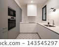 Modern kitchen with sleek white cabinets, gray accents, and patterned floor tiles. Features built-in appliances and a minimalist design. 143545297