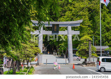 靜岡縣森町小國神社第一隻鳥居的美麗景色,陽光透過翠綠的樹葉灑下,照亮了通往神社內部的道路。 靜岡縣森町小國神社第一隻鳥居的美麗景色,陽光透過翠綠的樹葉灑下,照亮了通往神社內部的道路。 143545456