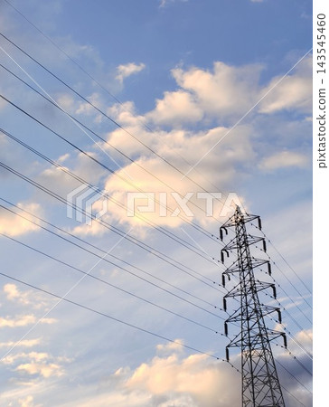 一座輸電塔高聳於傍晚的天空下,電線斜跨在塔身。 一座輸電塔高聳於傍晚的天空下,電線斜跨在塔身。 143545460