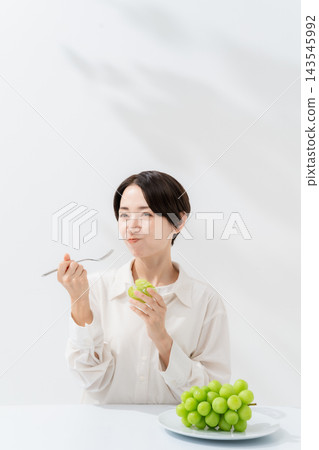 Woman eating shine muscat Woman eating shine muscat 143545992