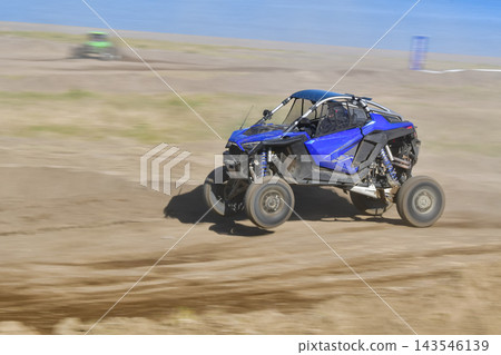 鏡頭緩緩移動,一輛藍色越野車飛馳在泥濘的賽道上。 鏡頭緩緩移動,一輛藍色越野車飛馳在泥濘的賽道上。 143546139