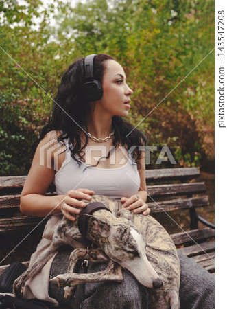 Woman Relaxing with Dog while Listening to Music Woman Relaxing with Dog while Listening to Music 143547208