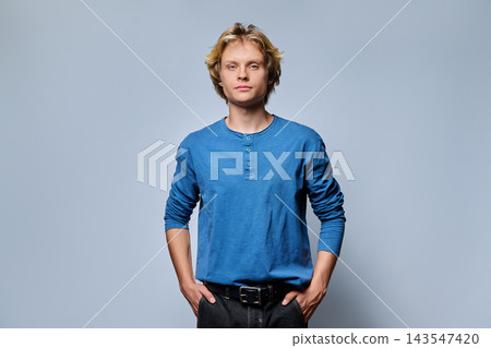 Confident young blonde man with hands in pockets portrait Confident young blonde man with hands in pockets portrait 143547420