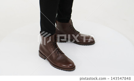 Man showcasing modern leather boots with laces, combining comfort and style for everyday and casual wear Man showcasing modern leather boots with laces, combining comfort and style for everyday and casual wear 143547848