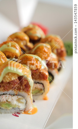 Spicy sushi rolls with tempura and avocado, drizzled with creamy sauces, gourmet Asian food takeaway Spicy sushi rolls with tempura and avocado, drizzled with creamy sauces, gourmet Asian food takeaway 143547859