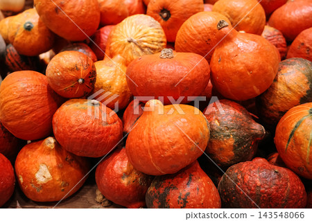 Close-up full frame background of many fresh ripe orange red pumpkins with natural texture and imperfections, autumn harvest and fall season market concept Close-up full frame background of many fresh ripe orange red pumpkins with natural texture and imperfections, autumn harvest and fall season market concept 143548066