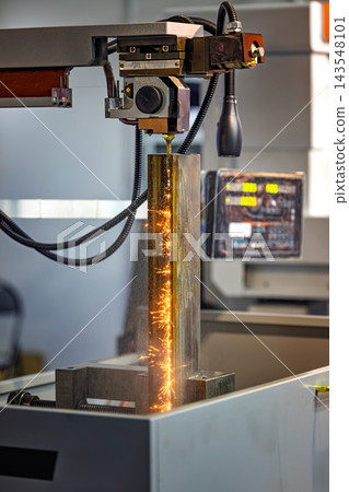 Wire EDM cutting of metal workpiece with sparks in industrial machine. Wire EDM cutting of metal workpiece with sparks in industrial machine. 143548101