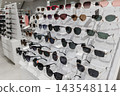 Eyewear display with assorted tinted frames in a fashion retail store. 143548114