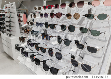 Eyewear display with assorted tinted frames in a fashion retail store. Eyewear display with assorted tinted frames in a fashion retail store. 143548114