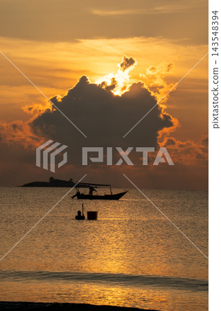 A stunning golden sunset illuminates a calm ocean, creating a dramatic silhouette of a fishing boat and a fisherman. Warm rays peek through clouds, enhancing this peaceful tropical seascape. A stunning golden sunset illuminates a calm ocean, creating a dramatic silhouette of a fishing boat and a fisherman. Warm rays peek through clouds, enhancing this peaceful tropical seascape. 143548394