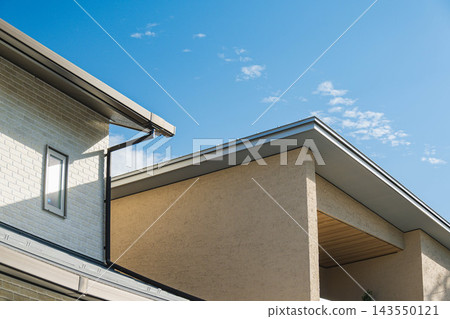 現代獨立式住宅的屋頂和外牆在藍天的襯托下格外醒目。 現代獨立式住宅的屋頂和外牆在藍天的襯托下格外醒目。 143550121