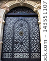 ancient medieval wrought iron door with ornate patterns and stone entry 143551107